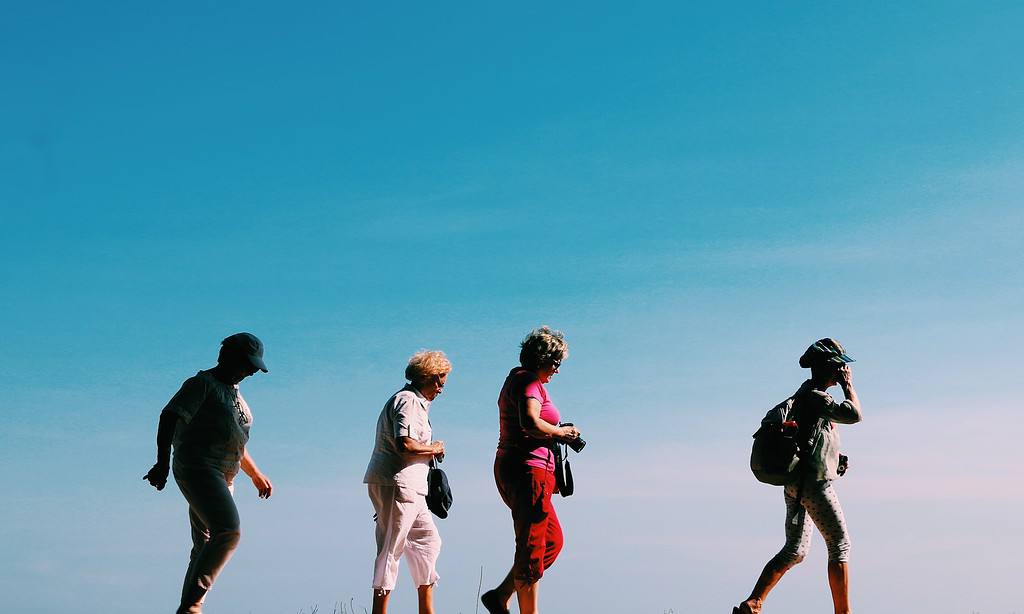 four women walking with sky as the background stock image